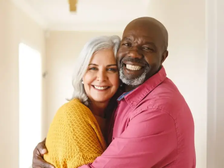 Casal sênior sorrindo com mais qualidade de vida após implantes dentários